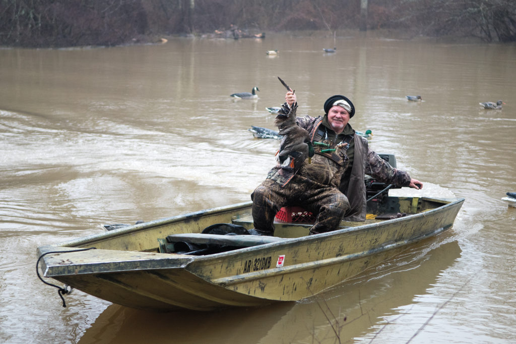 Harvey Beasley hoists a mallard shot during a hunt.