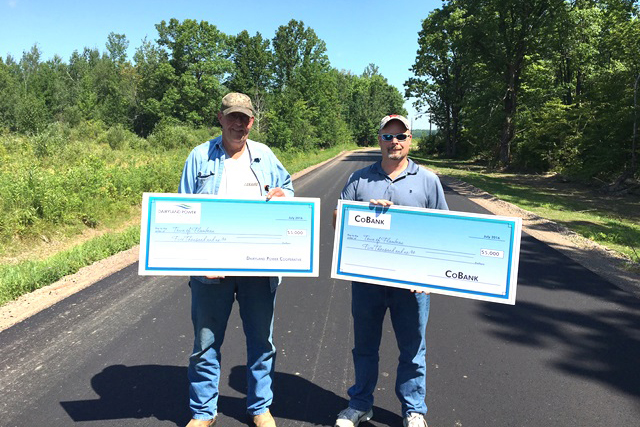 Town of Flambeau’s Dan Murray (l) and Dairyland Power Co-op’s Brad Foss stand on a newly paved road near Ladysmith, Wisconsin, which the G&T helped fund.