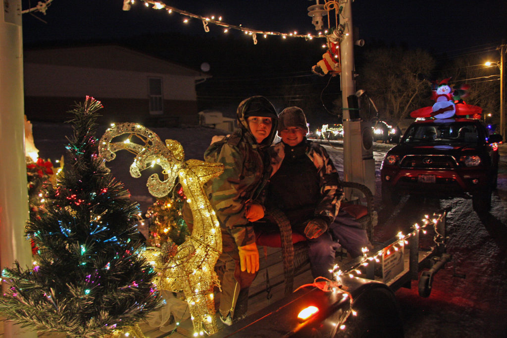 Spencer Lubken (l) and Ryder Downey, whose parents work for Powder River Energy Corp., ride on the co-op’s float during the annual Parade of Lights in Sundance, Wyo. (Photo By: Timothy Velder)