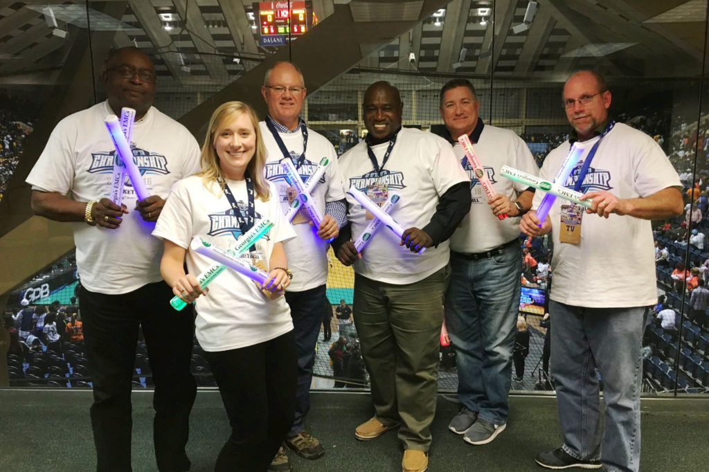 Flint Energies’ Jesse Lockhart (center( and other volunteers from Georgia’s electric cooperatives hand out light sticks at the Georgia high school basketball championships. (Photo By: Georgia EMC)