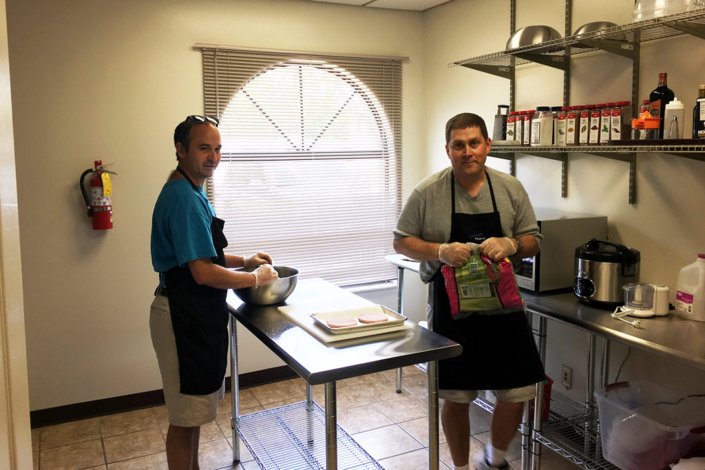 Justin Marquis (left) and Randy Stevens prepare lunch for other Vincent Academy members at the temporary facility which opened this month. (Photo By: David Lambert)