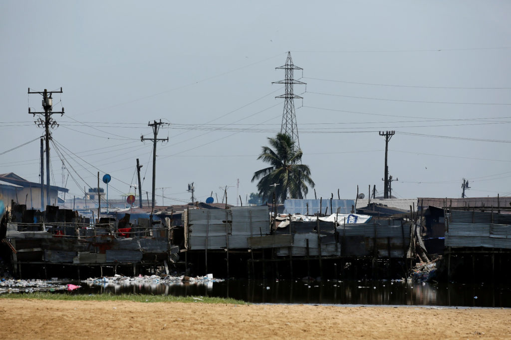 The shanty town of West Point sits under the shadow of large transmission lines in Monrovia, Liberia. (Photo By: NRECA International)