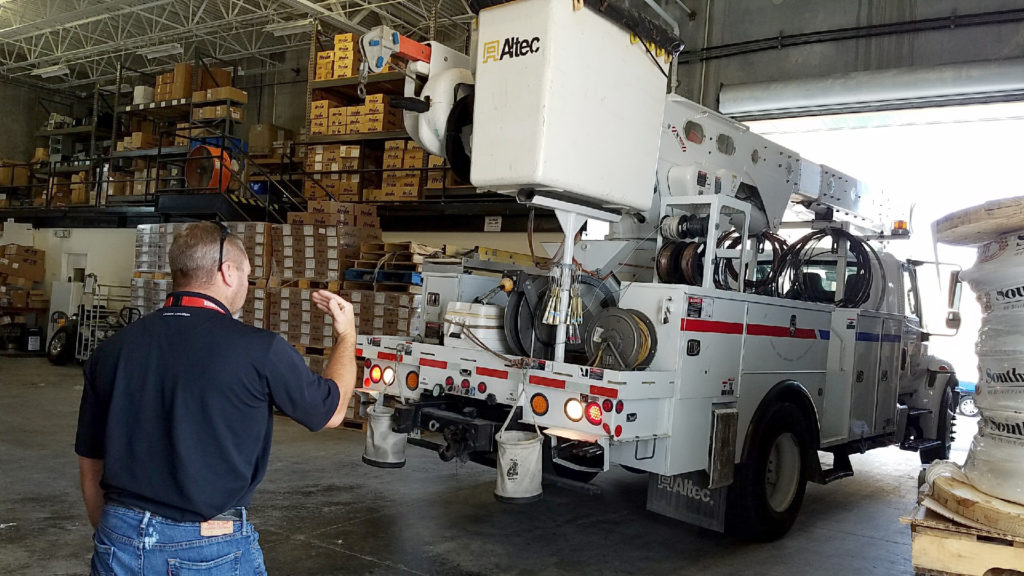 A Florida Keys EC staffer helps guide a co-op bucket truck into the warehouse to protect the vehicle from Hurricane Irma. (Photo By: Florida Keys EC)