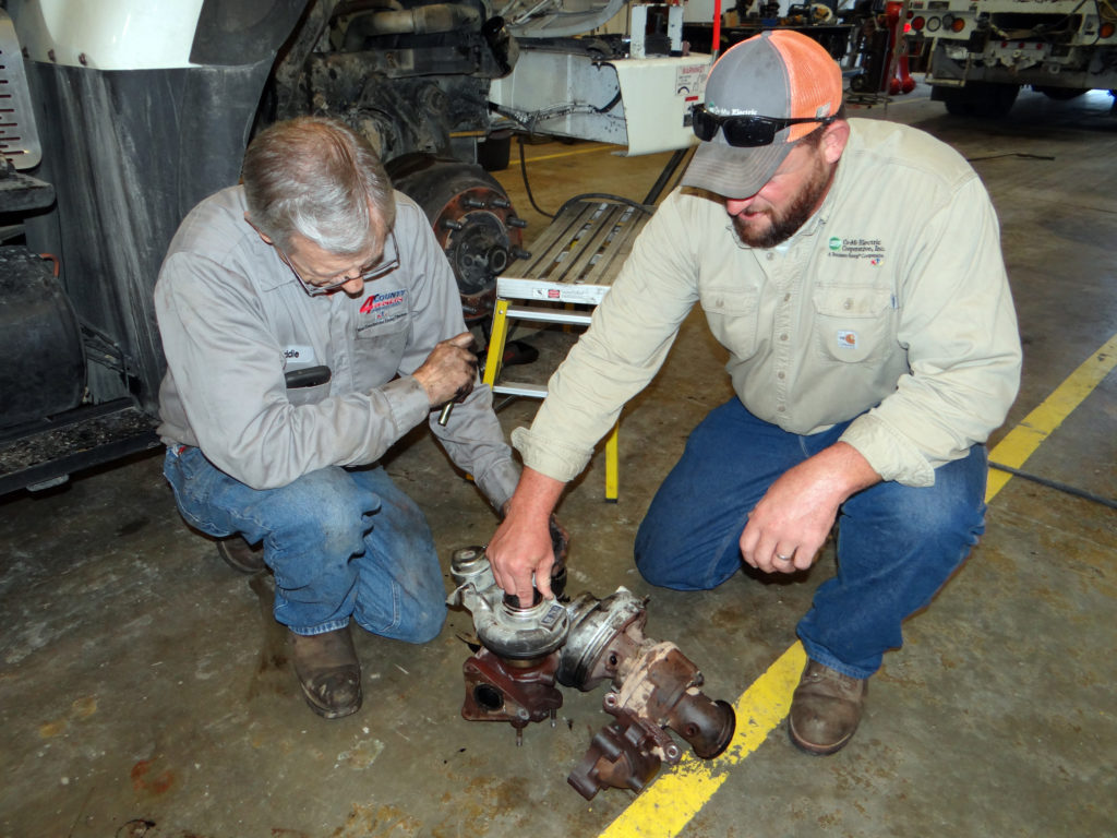 Eddie Pennington of 4-County EPA (l) and Grant Petree of Co-Mo Electric Cooperative examine a broken turbocharger that failed as Petree was headed to Florida after Hurricane Irma. (Photo By: Brad Barr/4-County EPA)