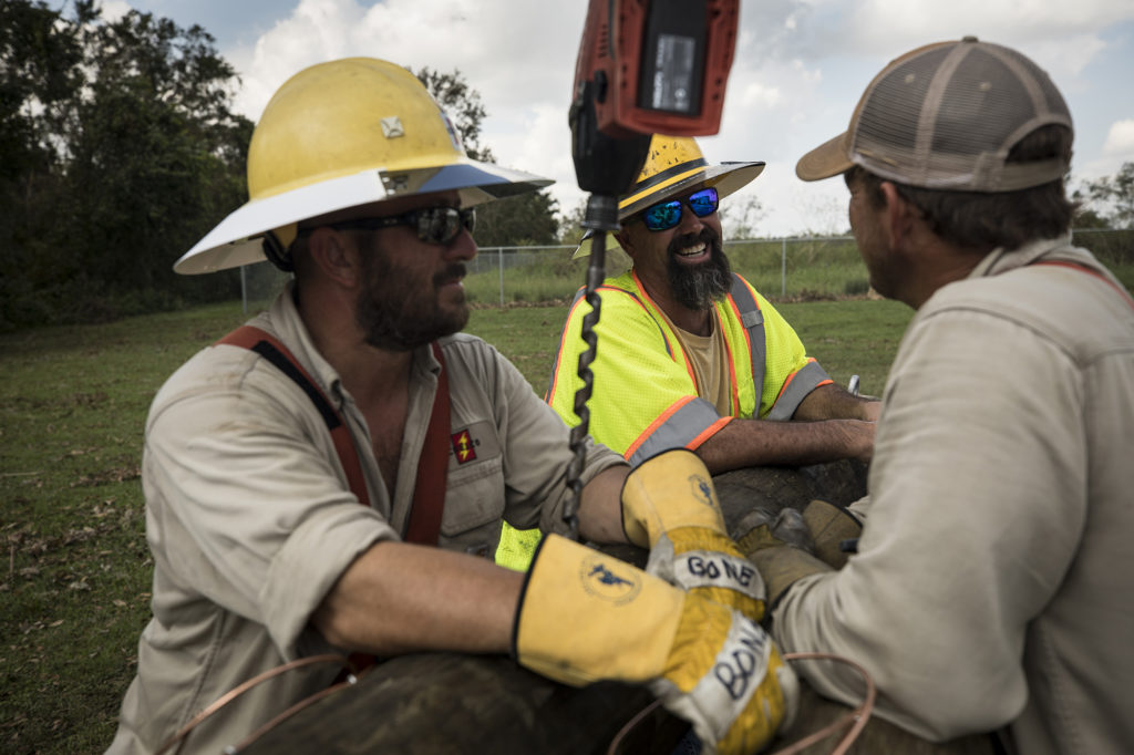 Choctawhatchee Electric linemen Jason Nowling, Mike Green, and Cody Dickey catch their breath while waiting for more supplies to restore power to members of the Glades Electric Cooperative. (Photos By: Garrett Hubbard for NRECA. © Garrett Hubbard 2017.)