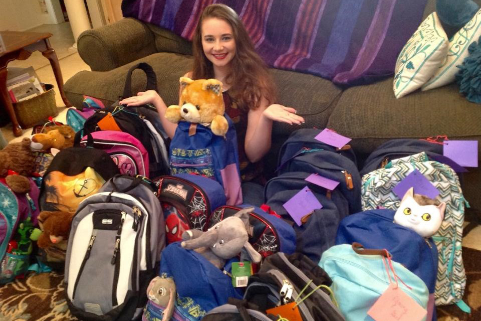 Eden Wallace is surrounded by backpacks she collected and stuffed for children entering foster care. (Photo Courtesy of Eden Wallace)
