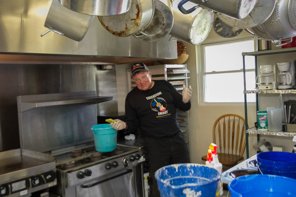 Geoff Oldfather didn't mind working in the kitchen, getting this cooking hood to shine. (Photo By: Luis Gomez Photos)