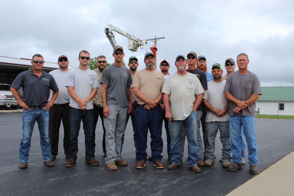 Regular safety training helped more than a dozen Shelby Electric co-op line crews save Kevin Carlen’s life. Carlen is seventh from the left. (Photo By: Kevin Bernson)
