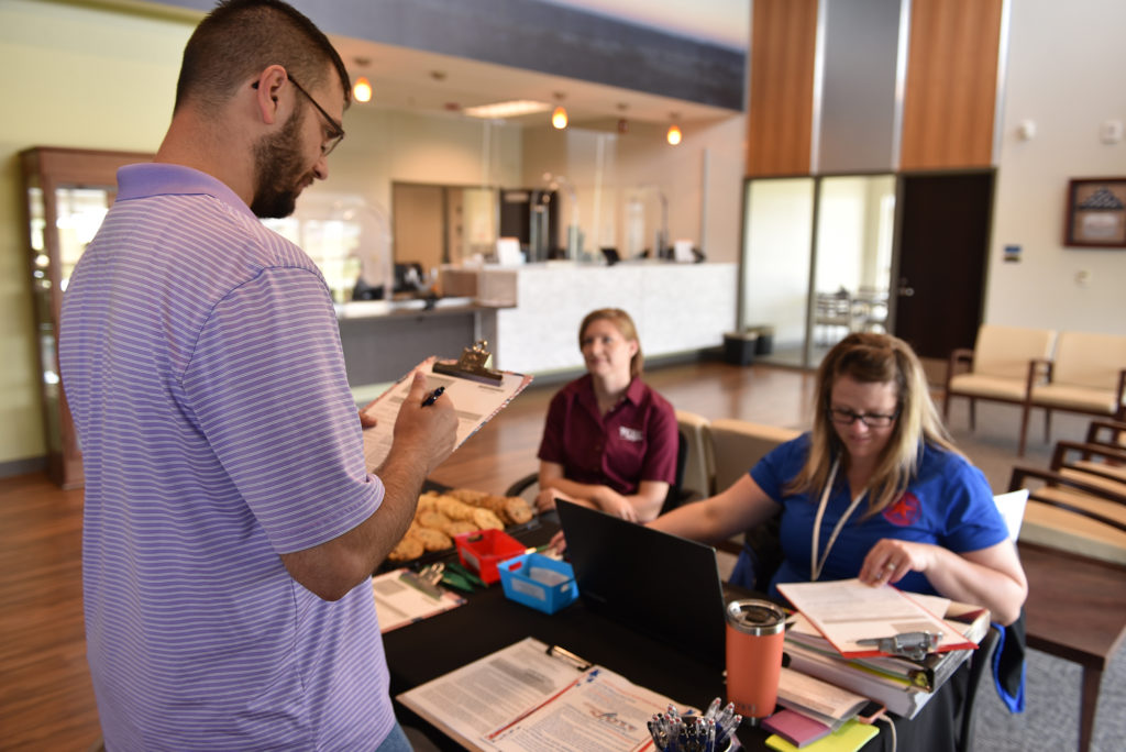 Tri-County Electric Cooperative’s Esther Guenther (left) and Texas County Election Board’s Sierra Martinez help register a voter in the co-op’s lobby during National Voter Registration Day. (Photo By: JuliAnn Graham)