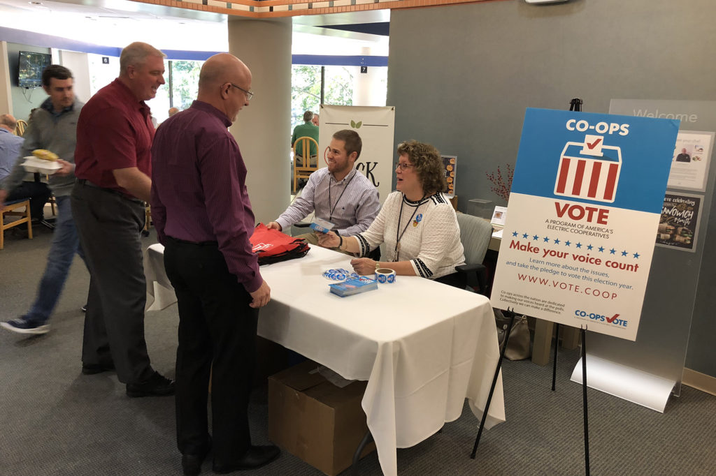 Kaleb Frady and Gale Cutler (seated l-r) of Georgia EMC talk to employees about NRECA’s Co-ops Vote project outside the Oglethorpe Power’s cafeteria. (Photo By: Georgia EMC)