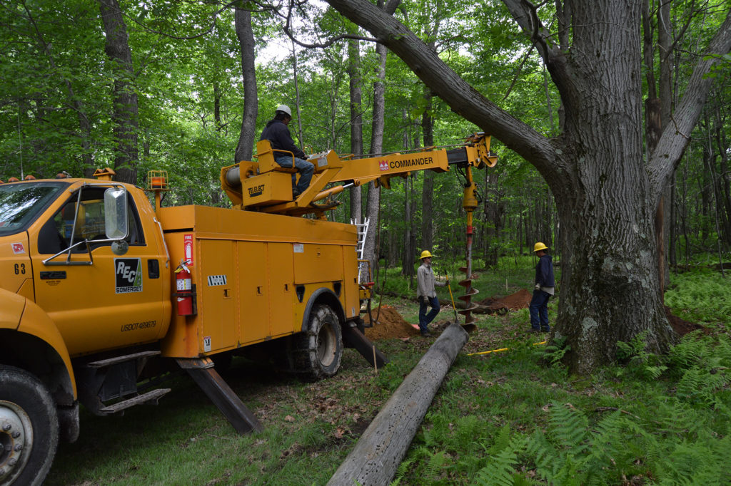 Crews from Somerset Rural Electric Cooperative set poles for a tree house at the Outdoor Odyssey camp in Boswell, Pennsylvania. (Photo By: Somerset REC) 