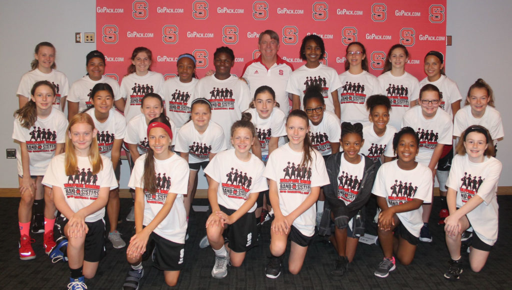 N.C. State coach Wes Moore, head of the women’s Wolfpack basketball team, poses with middle school campers last summer. (Photo Courtesy of NCEMCS)
