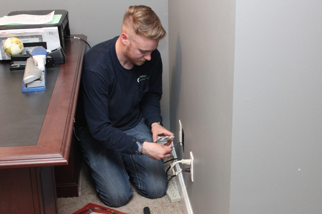 Broadband service technician Trey Haywood of Gibson Connect installs high-speed internet components in the home of a Gibson EMC member. (Photo By: Jenni Lynn Rachels/Gibson EMC)