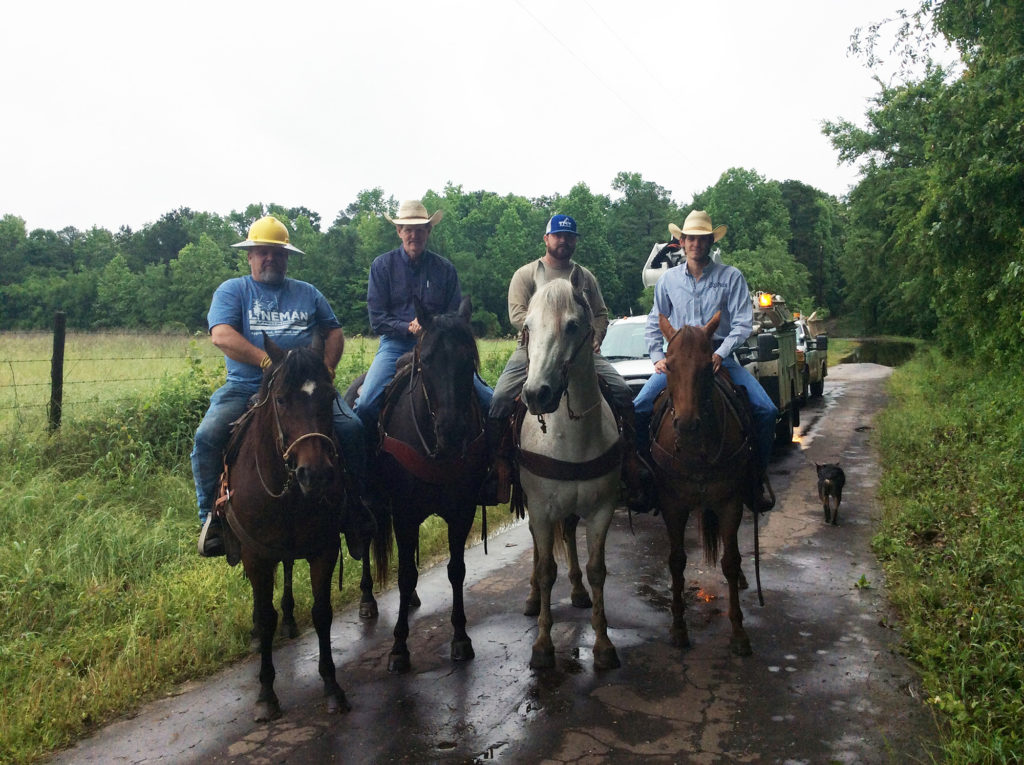 Upshur RECC service tech Sam Clemens (left) returns from a flooded area after repairing a line on the property of co-op member Wade Beckham, with Upshur RECC apprentice Cory Richardson and Beckham’s son Brent. (Photo By: Upshur RECC)