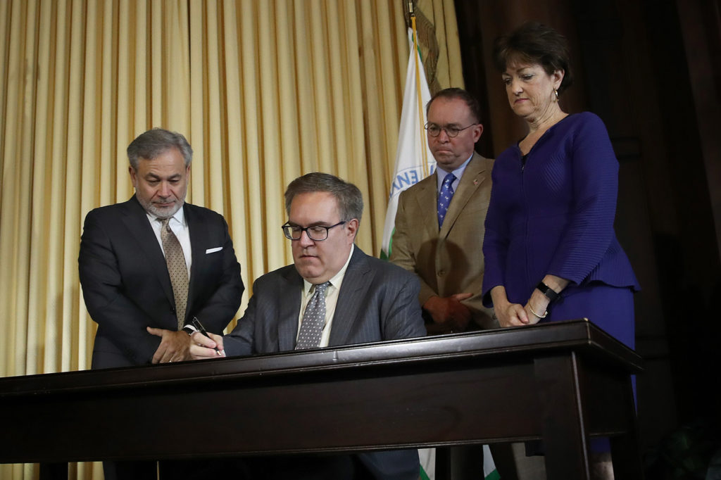 EPA Administrator Andrew Wheeler, seated, signs the final Affordable Clean Energy rule on June 19 to regulate carbon dioxide emissions from power plants. (Photo By: Win McNamee, Getty Images)