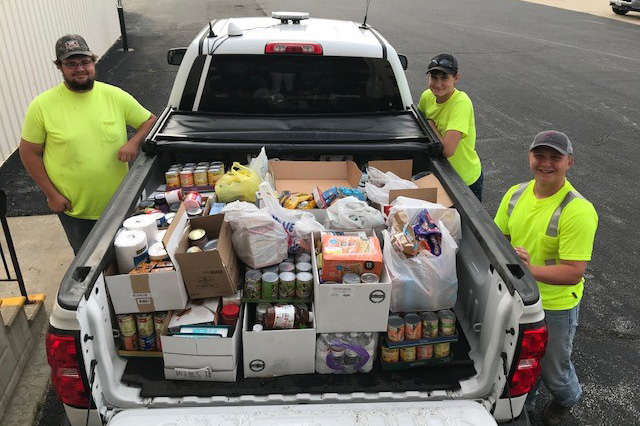 Members of Eastern Illini EC’s summer crew—Andy Blackford (left), Dylan Polson (right foreground) and Tanner Coe (right background)—loaded 909 pounds of food aimed at fighting hunger in in the co-op’s southern territory.  (Photo By: EIEC)