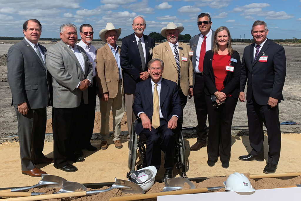Guadalupe Valley Electric Cooperative leaders, Texas Gov. Greg Abbott (seated) and AW Texas executives attend the groundbreaking of an auto transmission plant in Cibolo Texas. (Photo Courtesy of GVEC)