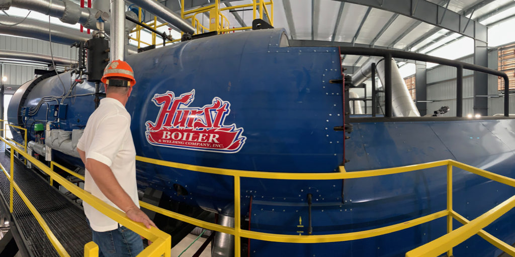 Carolina Poultry Power Director of Operations Peyton Orr checks the water/air tube section of a Hurst boiler at the heart of the CPP system. (Photo By: Claire Edwards)