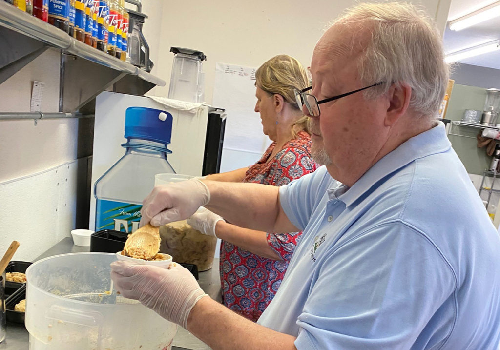 Mohave Electric Cooperative’s Ardie Lauxman and Donna Hill prepare meals for seniors in a coffeehouse that was converted into a community kitchen. (Photo By: Anita Gill)