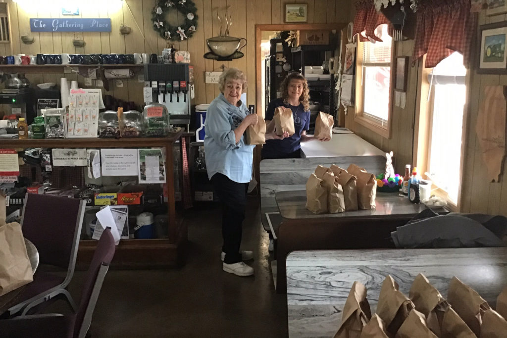 EnerStar Electric Co-op supports local restaurants shut down by pandemic with community drive-thru sack lunches. Shown are Pat Rhoades and Jeanenna Sanders. (Photo By: Mike Clark)