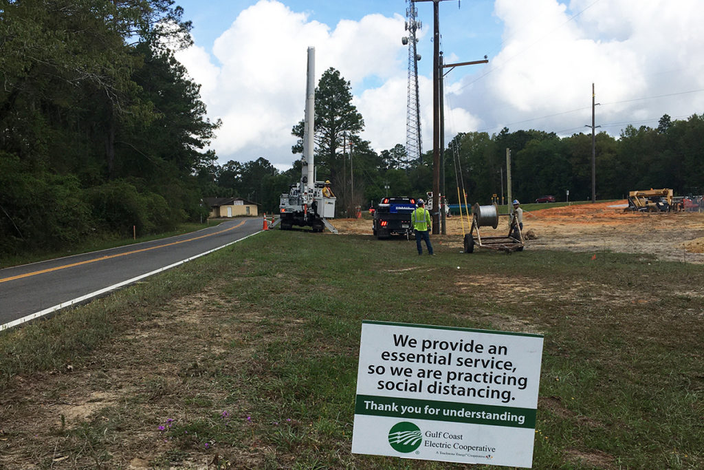Line crews alert public to social distancing practices while tending to an electric  power line. (Photo courtesy of Gulf Coast Electric Cooperative
