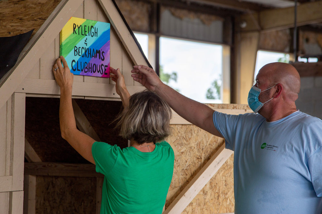 At Berkeley Electric Cooperative, volunteers put the finishing touches on a wooden playhouse built by employees for a co-worker with a sick child. (Photo By: Micah Ponce) 