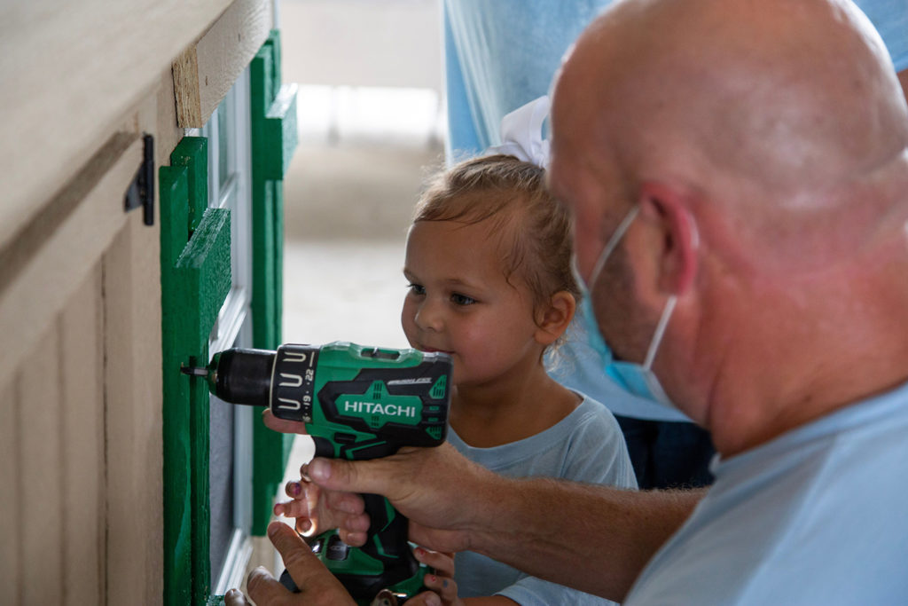 Berkeley Electric Cooperative’s Thomas Barnette gets help from Ryleigh Brown, 4, while building a playhouse for her and brother, who’s battling cancer. (Photo By: Micah Ponce)