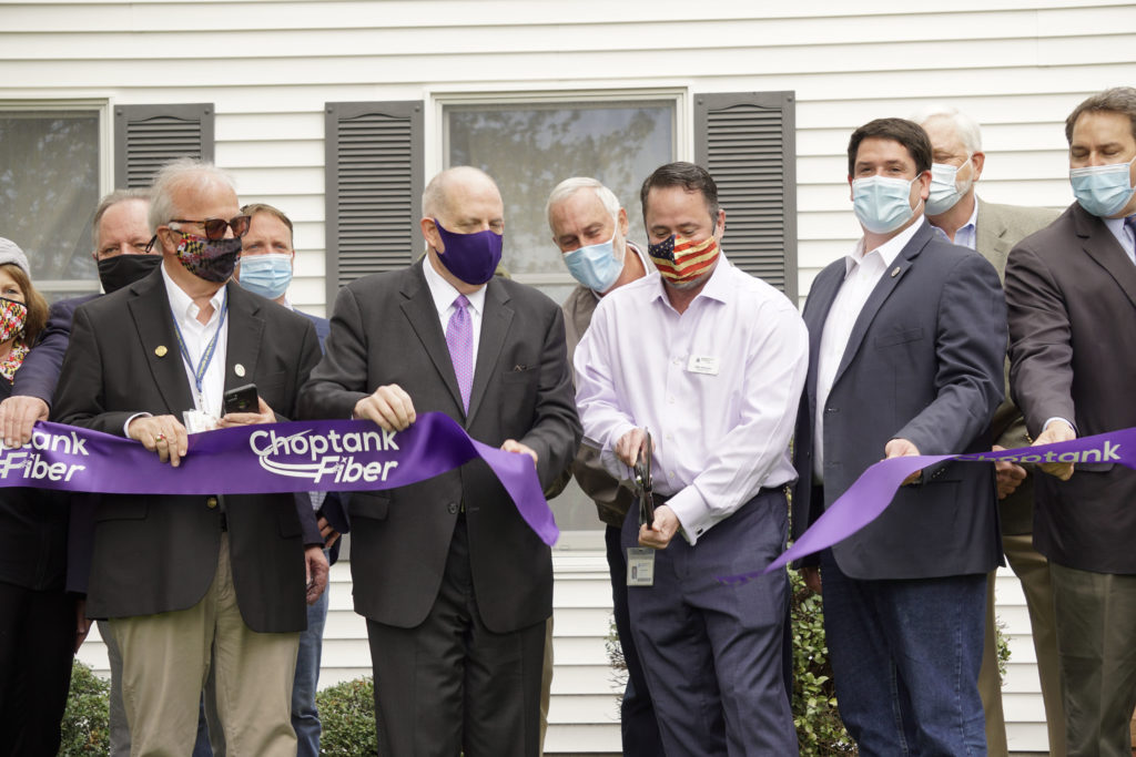 Choptank Electric CEO Mike Malandro, alongside Maryland Gov. Larry Hogan (left), cuts the ribbon officiating its first broadband connection to a Denton, Maryland, family whose co-op ties go back to 1939. (Photo By: Alexis Matsui/NRECA)